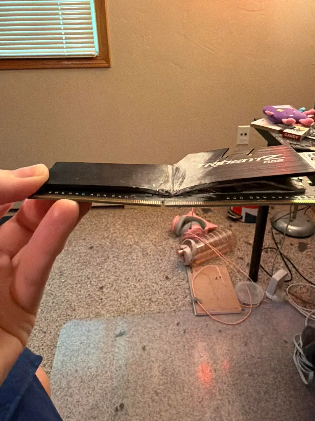 Damaged gaming PC with shattered tempered glass and deformed G.SKILL memory module
