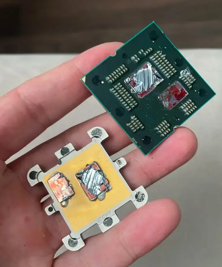 Damaged AMD Ryzen 7 7800X3D CPU showing bulging and burning