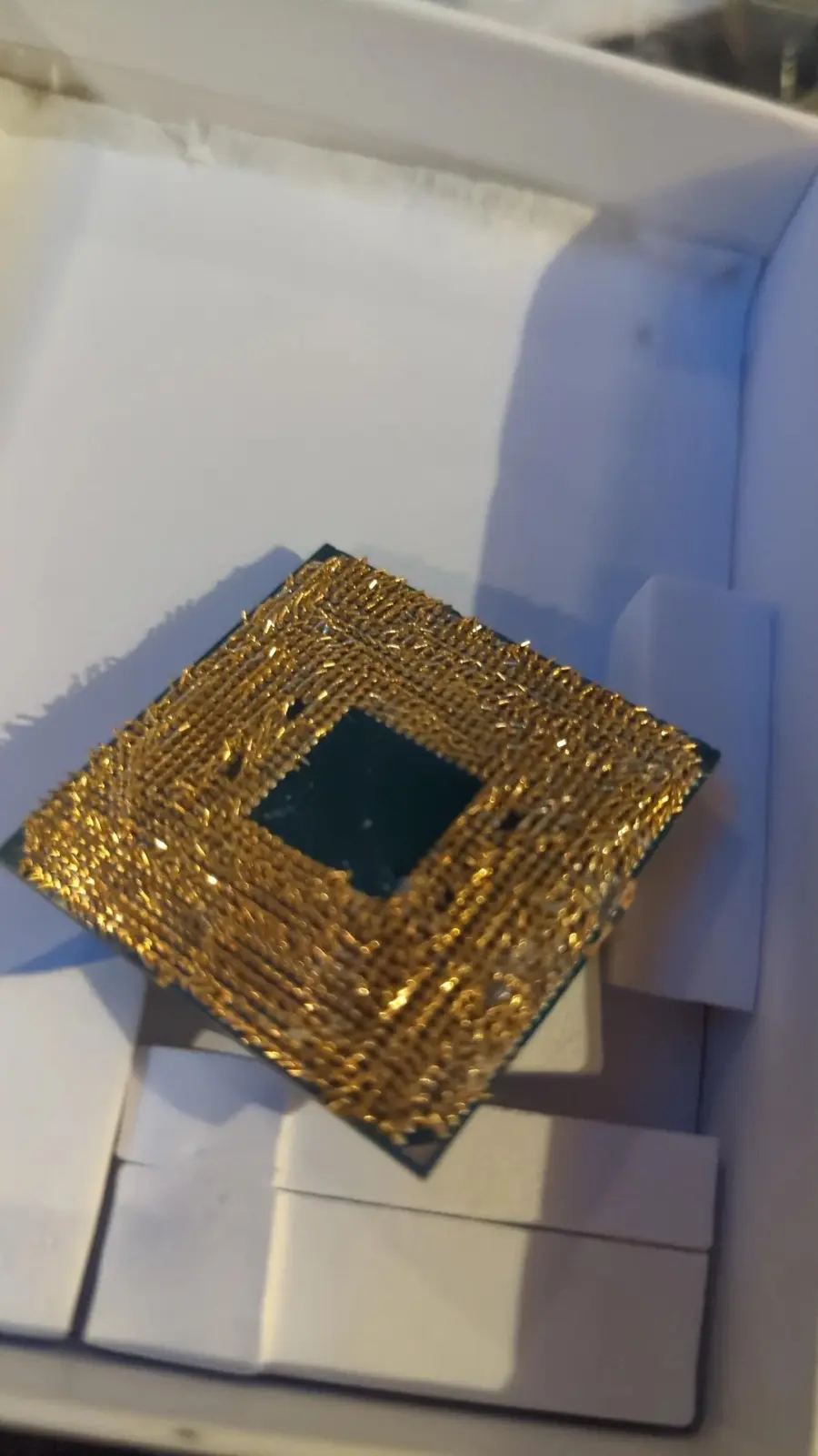 Damaged AMD Ryzen 5 3600X CPU with bent pins and warped heat spreader