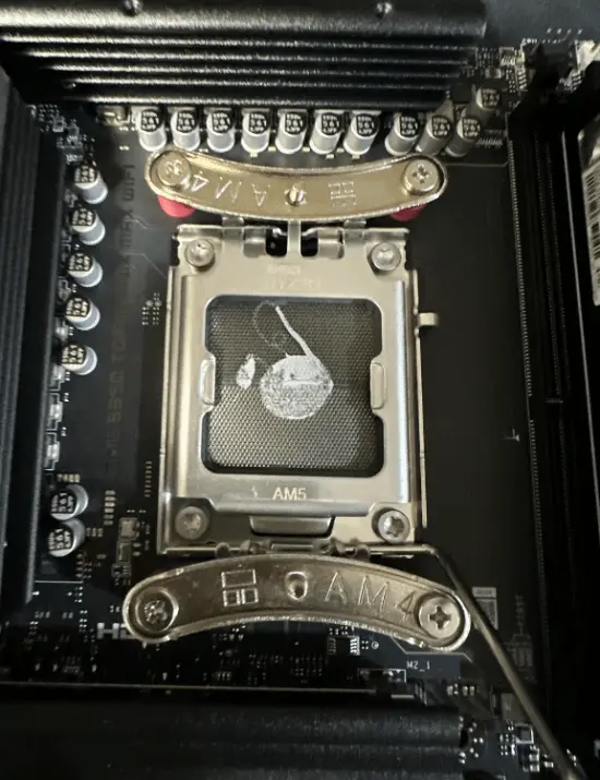 Motherboard CPU socket heavily contaminated with thermal paste
