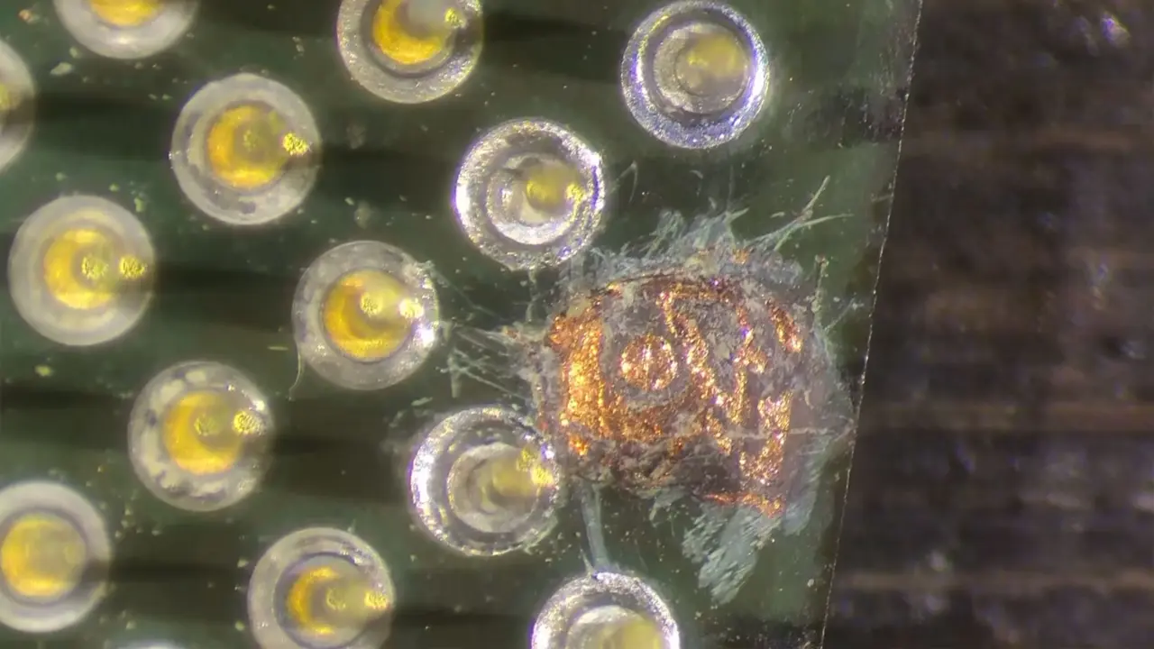 Close-up of the Intel Celeron 1200 substrate repair showing the donor pin soldering work